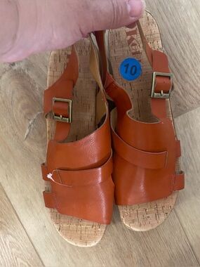 Women’s Korks platform wedge sandals feature a cork sole slingback buckle.